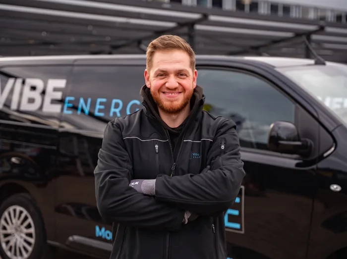 Monteurs met bus bij een woning, panelen worden op het dak gelegd